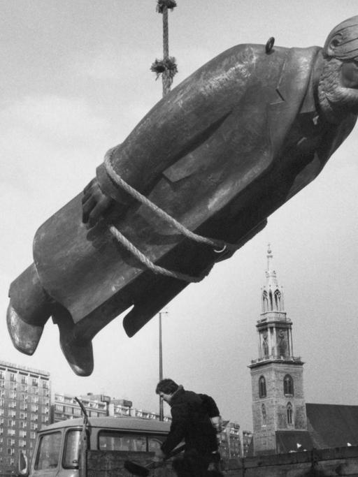 Eine große Engels-Statue hängt an einem Seil beim Aufbau des Marx-Engels-Forums in Berlin 1986.
