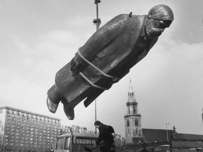 Eine große Engels-Statue hängt an einem Seil beim Aufbau des Marx-Engels-Forums in Berlin 1986.