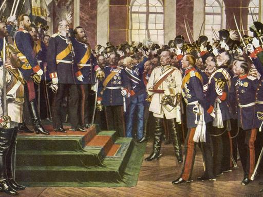 Wilhelm I. König von Preußen bei der Proklamation zum ersten Kaiser von Deutschland, 1871 im Spiegelsaal von Versailles. Otto von Bismarck, deutscher Kanzler, steht im weißen Anzug in der Mitte. 