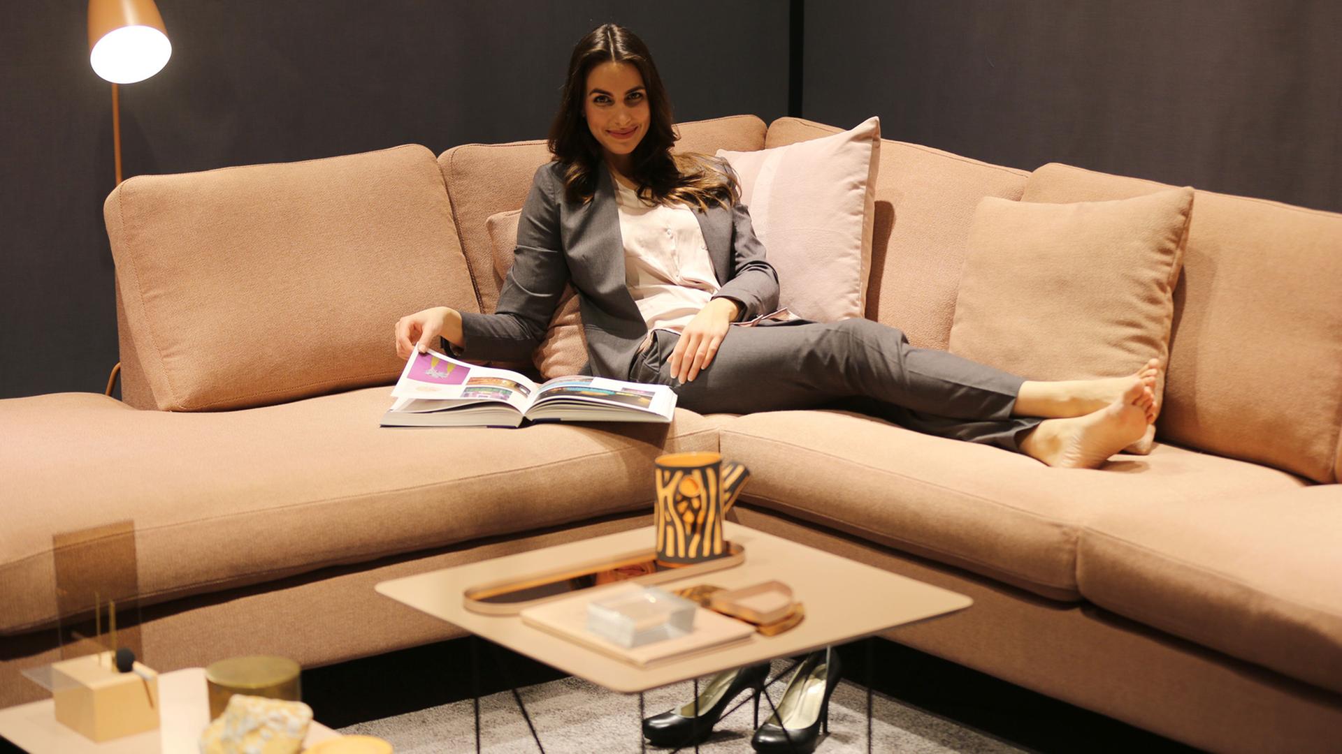 Ein Model sitzt auf einem Sofa in der Modefarbe rosa: Gesehen auf der Internationalen Modemesse in Köln im Januar 2016 Ein Model sitzt auf einem Sofa in der Modefarbe rosa: Gesehen auf der Internationalen Modemesse in Köln im Januar 2016