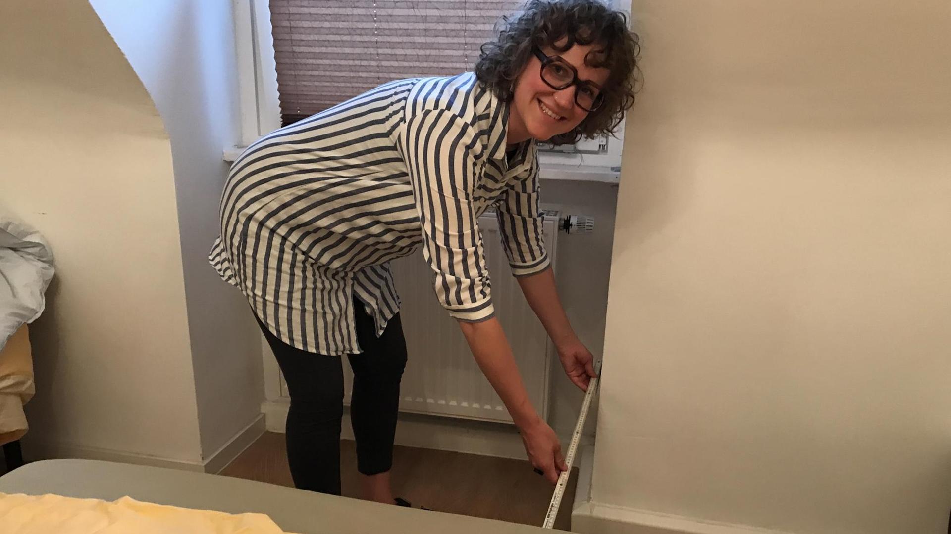 Maike Lautenschütz in ihrer Kölner Zweizimmerwohnung. Sie misst den Platz fürs Kinderbett aus. Maike Lautenschütz in ihrer Kölner Zweizimmerwohnung. Sie misst den Platz fürs Kinderbett aus.