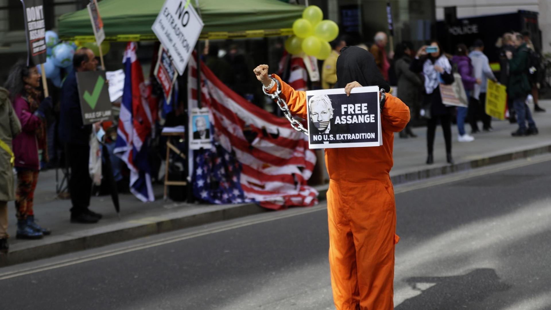 Ein maskierter Demonstrant hat sich als Gefängnisinsasse verkleidet und hält am 1. Oktober 2020 in London ein Schild mit dem Konterfei von julian Assange und der Aufschrift "Free Assange" in der Hand. Ein maskierter Demonstrant hat sich als Gefängnisinsasse verkleidet und hält am 1. Oktober 2020 in London ein Schild mit dem Konterfei von julian Assange und der Aufschrift "Free Assange" in der Hand.