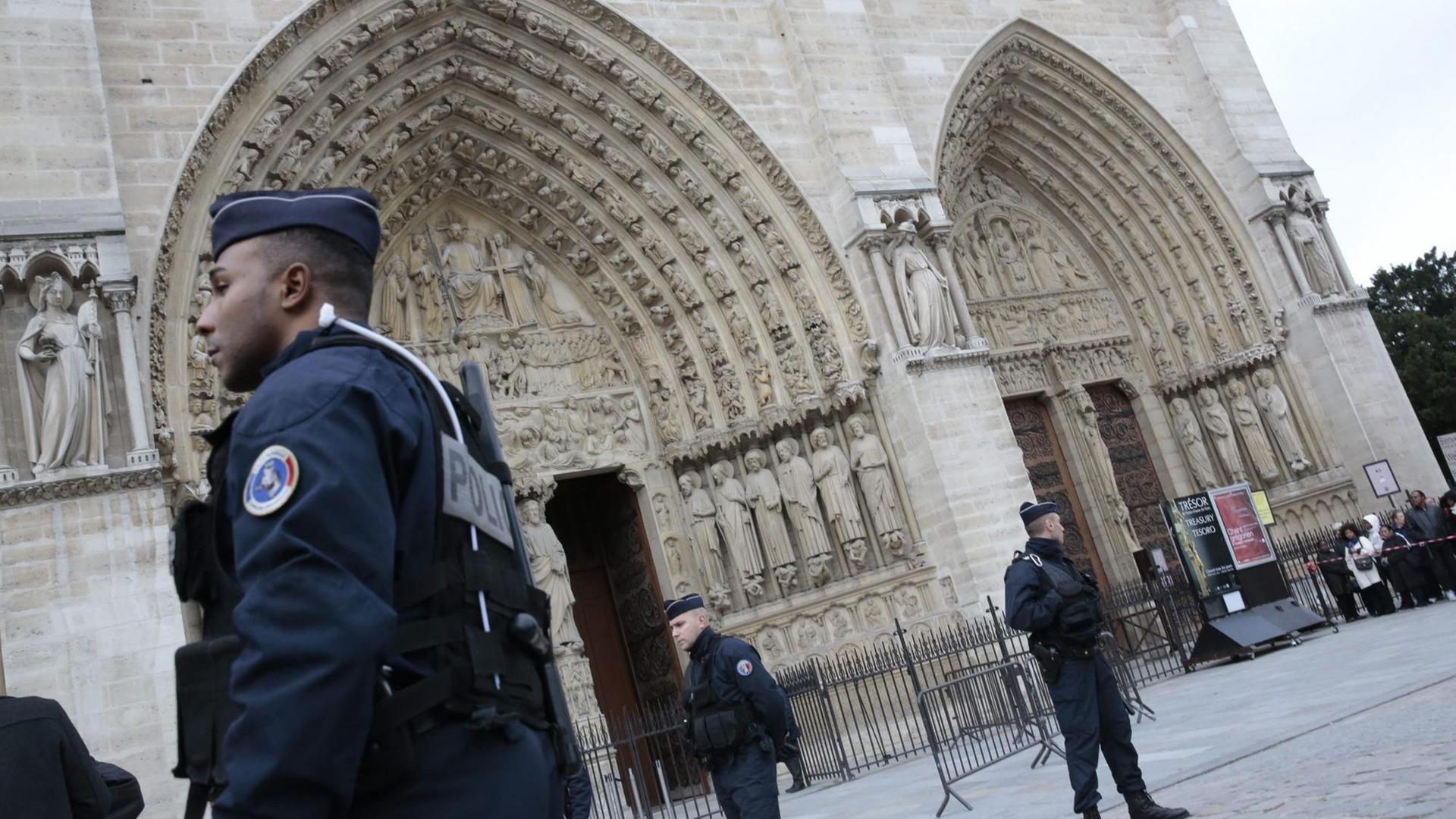 Polizisten stehen vor dem Hauptportal der Kirche Notre Dame in Paris Polizisten stehen vor dem Hauptportal der Kirche Notre Dame in Paris