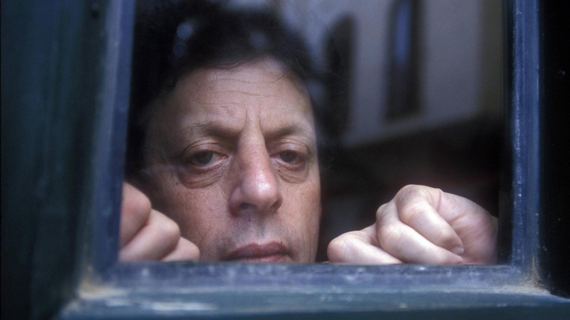Künstlerisches Foto mit dem Komponisten Philip Glass (Kopf) hinter einem antiken blauen Glasfenster um 1994 Künstlerisches Foto mit dem Komponisten Philip Glass (Kopf) hinter einem antiken blauen Glasfenster um 1994