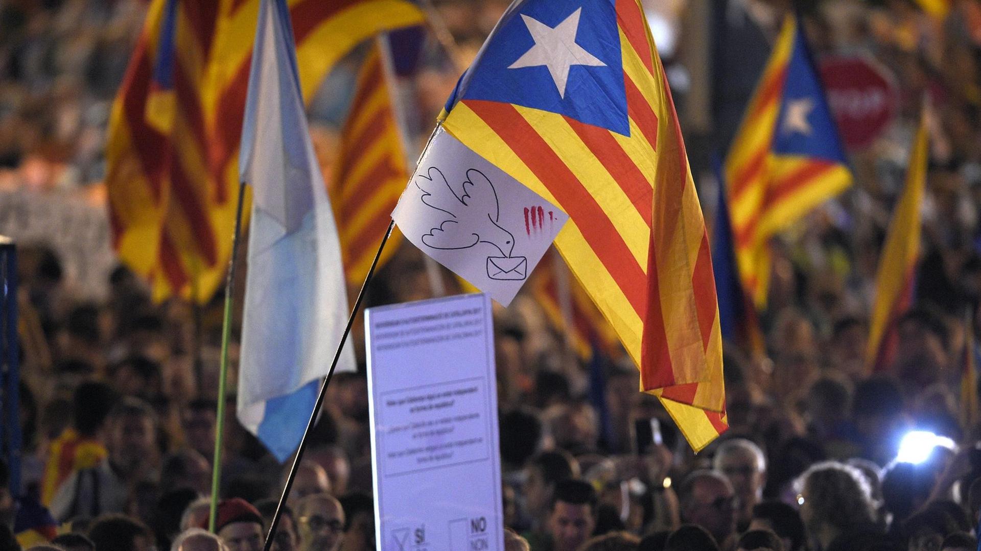 Viele Menschen schwenken katalanische Flaggen in Barcelona.
