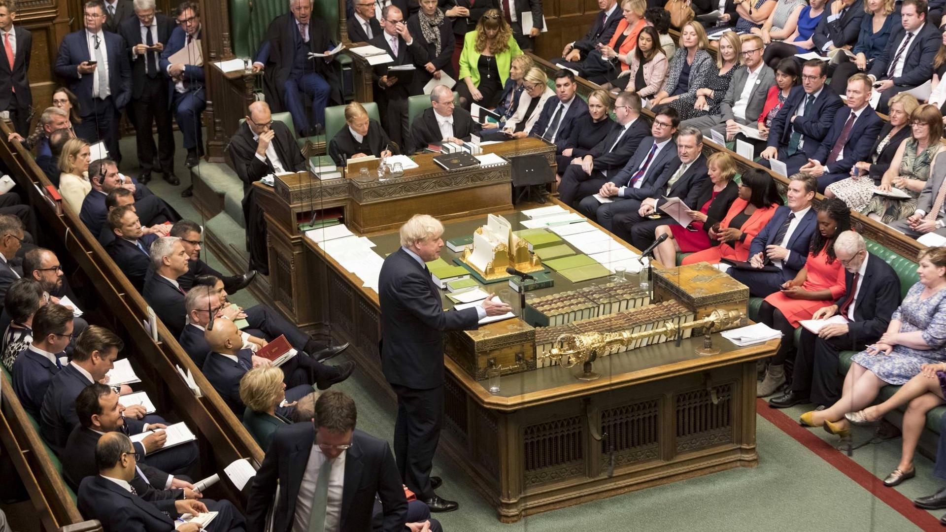 Blick ins britische Unterhaus. Die Abgeordneten sitzen in den grünledernen Bänken, während Premierminister Boris Johnson eine Rede hält. Blick ins britische Unterhaus. Die Abgeordneten sitzen in den grünledernen Bänken, während Premierminister Boris Johnson eine Rede hält.
