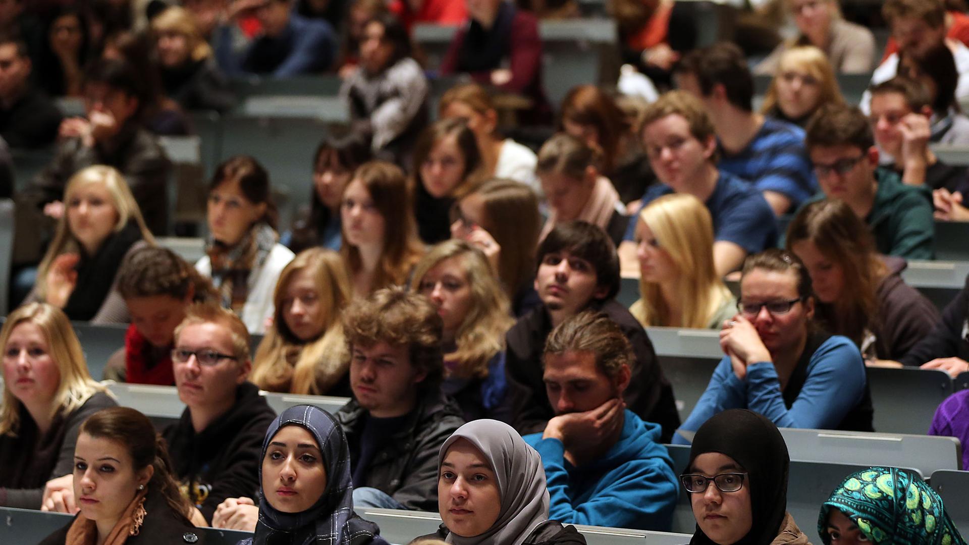 Studenten verfolgen in Köln in der Aula Universität eine Veranstaltung. Studenten verfolgen in Köln in der Aula Universität eine Veranstaltung.