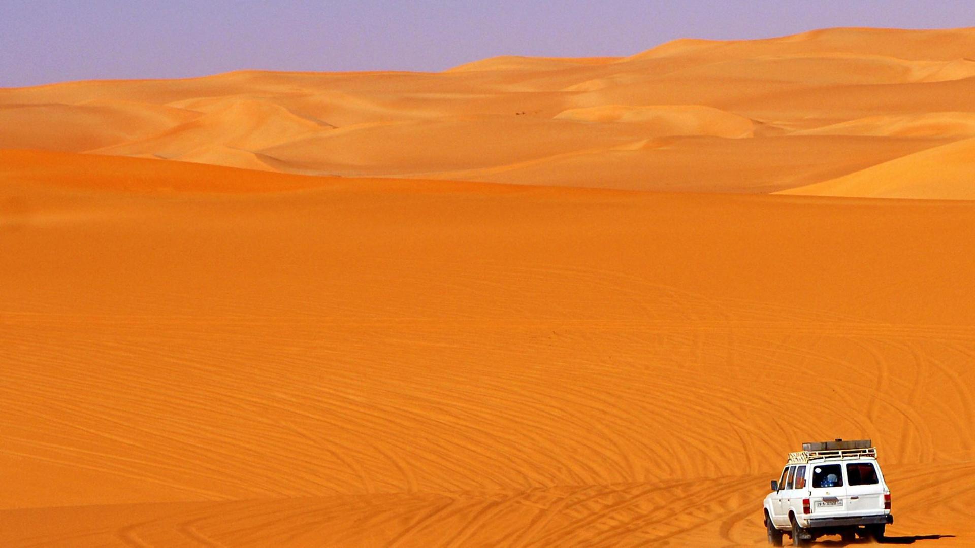Geländefahrzeug fährt in den Sanddünen im Ubari Sandmeer, Sahara, Libyen, Afrika Geländefahrzeug fährt in den Sanddünen im Ubari Sandmeer, Sahara, Libyen, Afrika