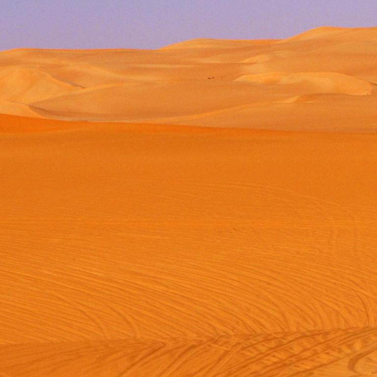 Geländefahrzeug fährt in den Sanddünen im Ubari Sandmeer, Sahara, Libyen, Afrika