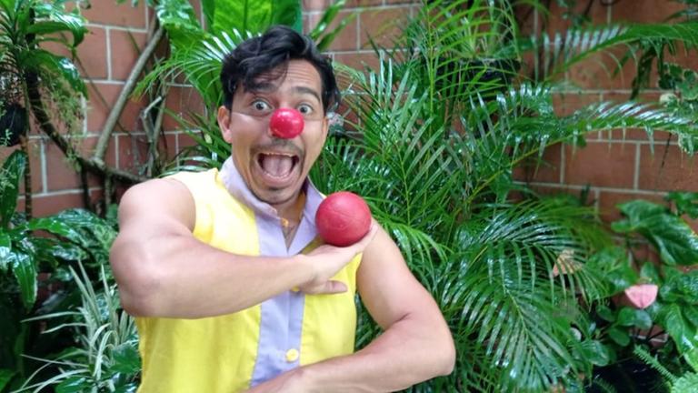 Porträt von Eduardo Barahona mit roter Clownsnase, der einen roten Ball balanciert. Porträt von Eduardo Barahona mit roter Clownsnase, der einen roten Ball balanciert.