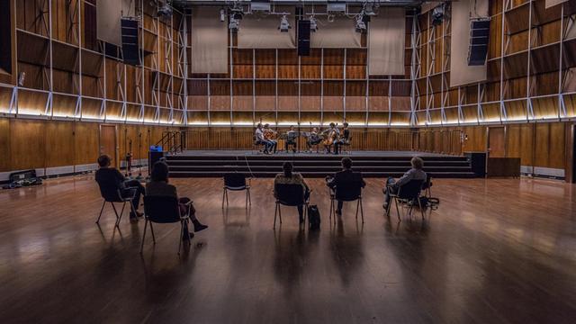Musiker spielen auf der Bühne im holzgetäfelten Dlf Kammermusiksaal, im Raum vereinzelt fünf Zuhörer