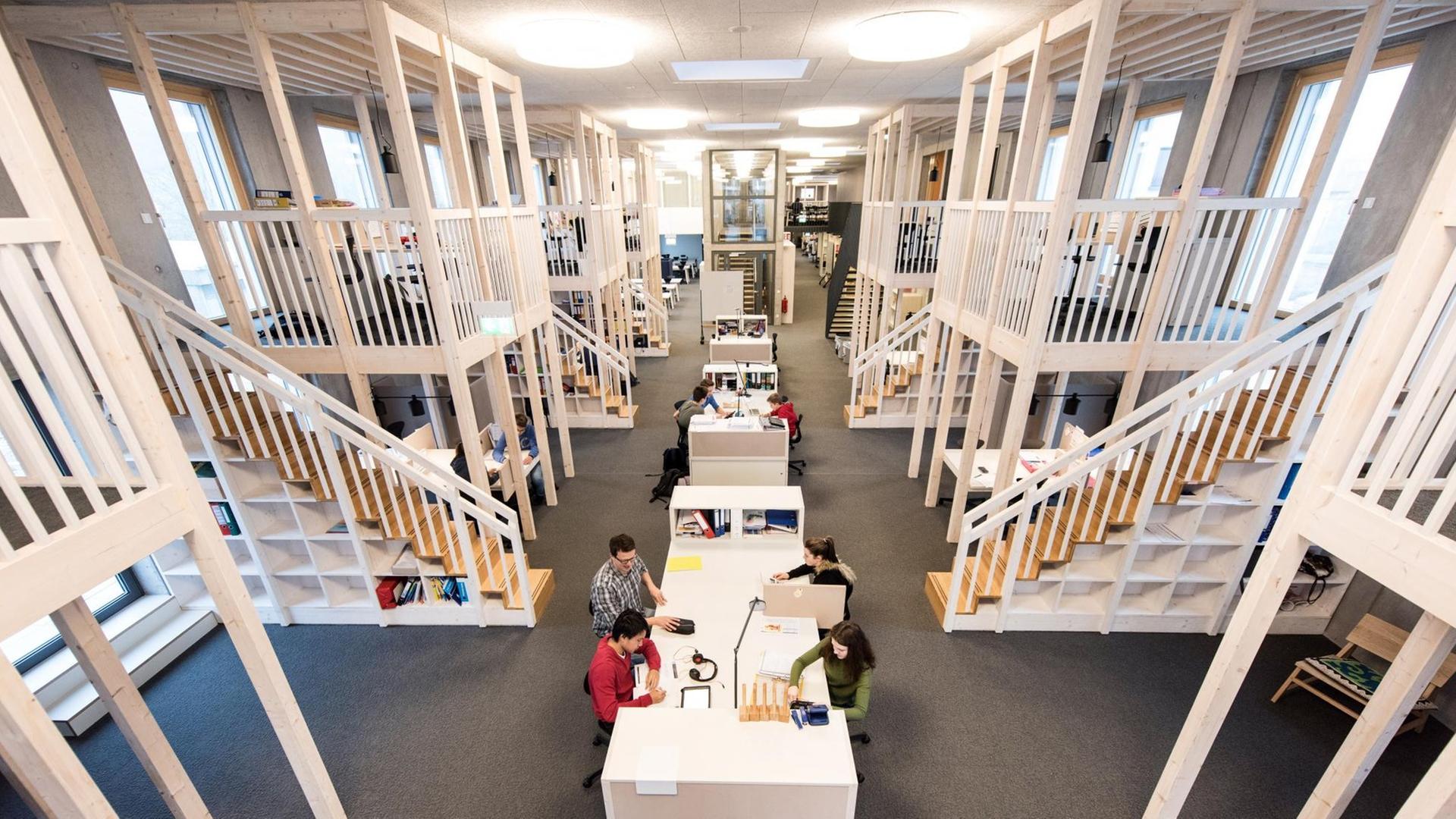 Eine helle Halle mit Treppen links und rechts und Regalen und in der Mitte sitzen Schüler in kleinen Teams an Tischen: Blick in die Alemannenschule in Wutöschingen Eine helle Halle mit Treppen links und rechts und Regalen und in der Mitte sitzen Schüler in kleinen Teams an Tischen: Blick in die Alemannenschule in Wutöschingen