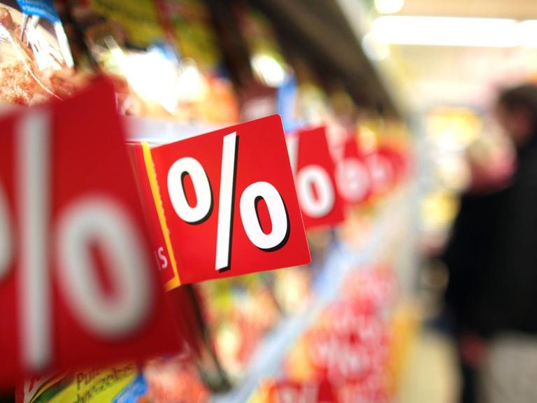 Ein Kunde steht in Köln in einem Rewe-Supermarkt an einem Regal.