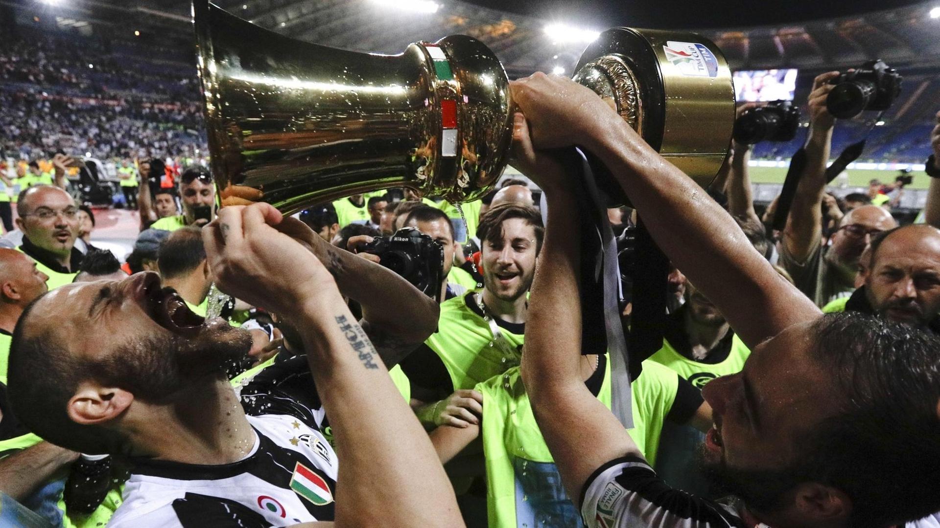 Turins Leonardo Bonucci trinkt aus dem Pokal und jubelt mit seiner Mannschaft über den Sieg im Pokalfinale der Coppa Italia. Turins Leonardo Bonucci trinkt aus dem Pokal und jubelt mit seiner Mannschaft über den Sieg im Pokalfinale der Coppa Italia.
