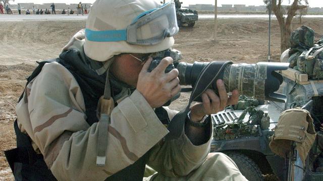 Der Fotograf Maurizio Gambarinij sitzt im Jahr 2003 auf einem Panzer, im Süden von Baghdad im Irak