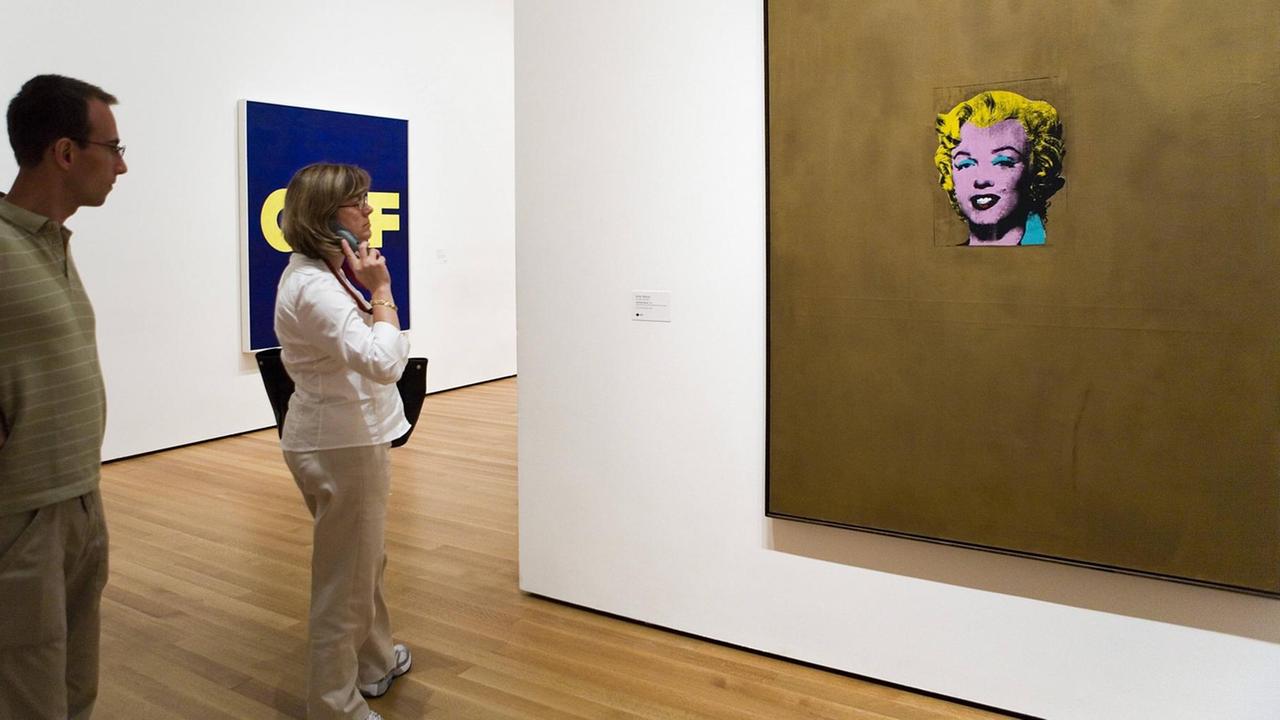Eine Besucherin im Museum of Modern Art in New York betrachtet Andy Warhols "Marilyn Monroe".