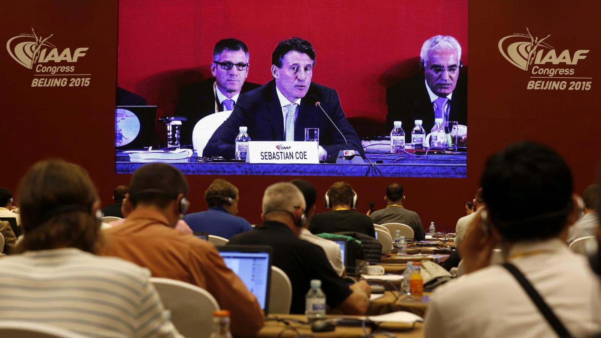 Sebastian Coe auf einer großen Leinwand, davor Delegierte. Sebastian Coe auf einer großen Leinwand, davor Delegierte.