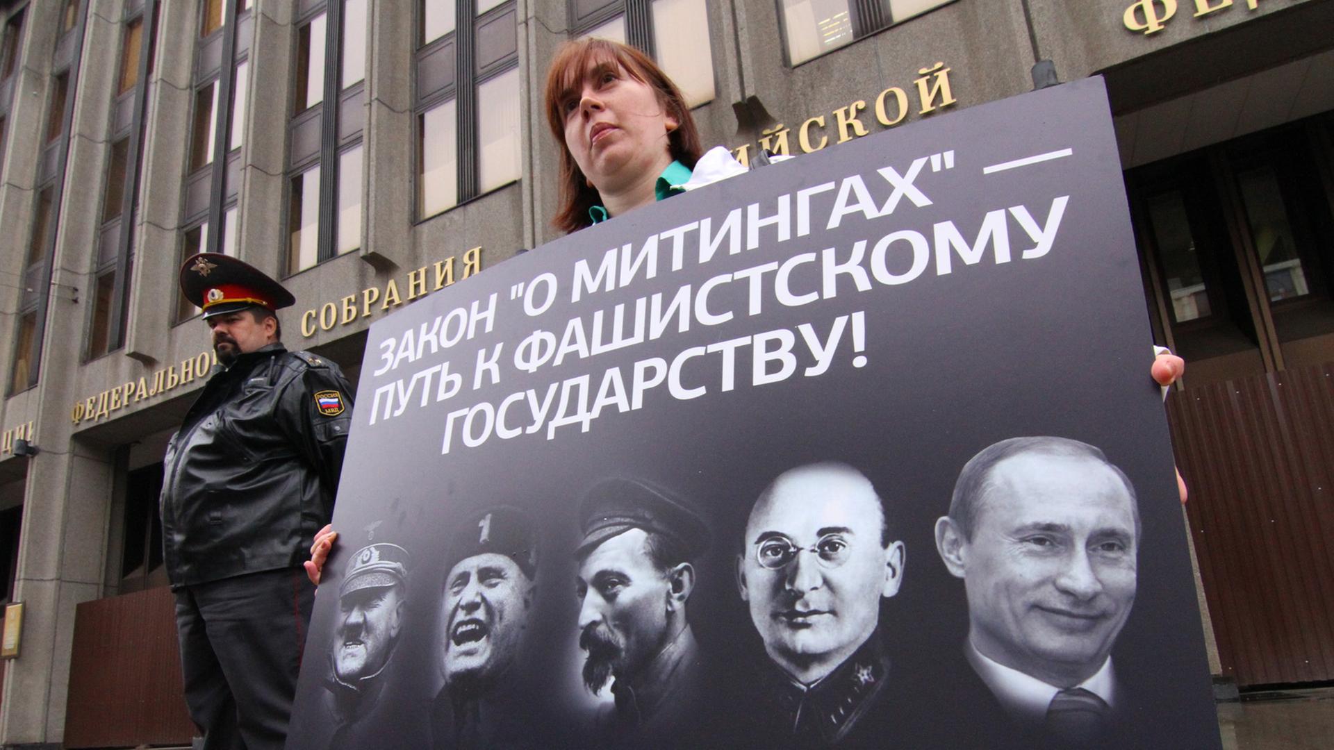 Demonstranten zeigen in Moskau ein Plakat mit Porträts von Adolf Hitler, Benito Mussolini, Felix Dzerzhinsky, Lavrenty Beria und Wladimir Putin. Demonstranten zeigen in Moskau ein Plakat mit Porträts von Adolf Hitler, Benito Mussolini, Felix Dzerzhinsky, Lavrenty Beria und Wladimir Putin.
