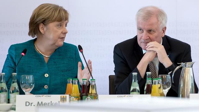 Bundeskanzlerin Angela Merkel (CDU) und der bayerische Ministerpräsident Horst Seehofer (CSU) sitzen während der Fraktionsvorsitzendenkonferenz von CDU und CSU