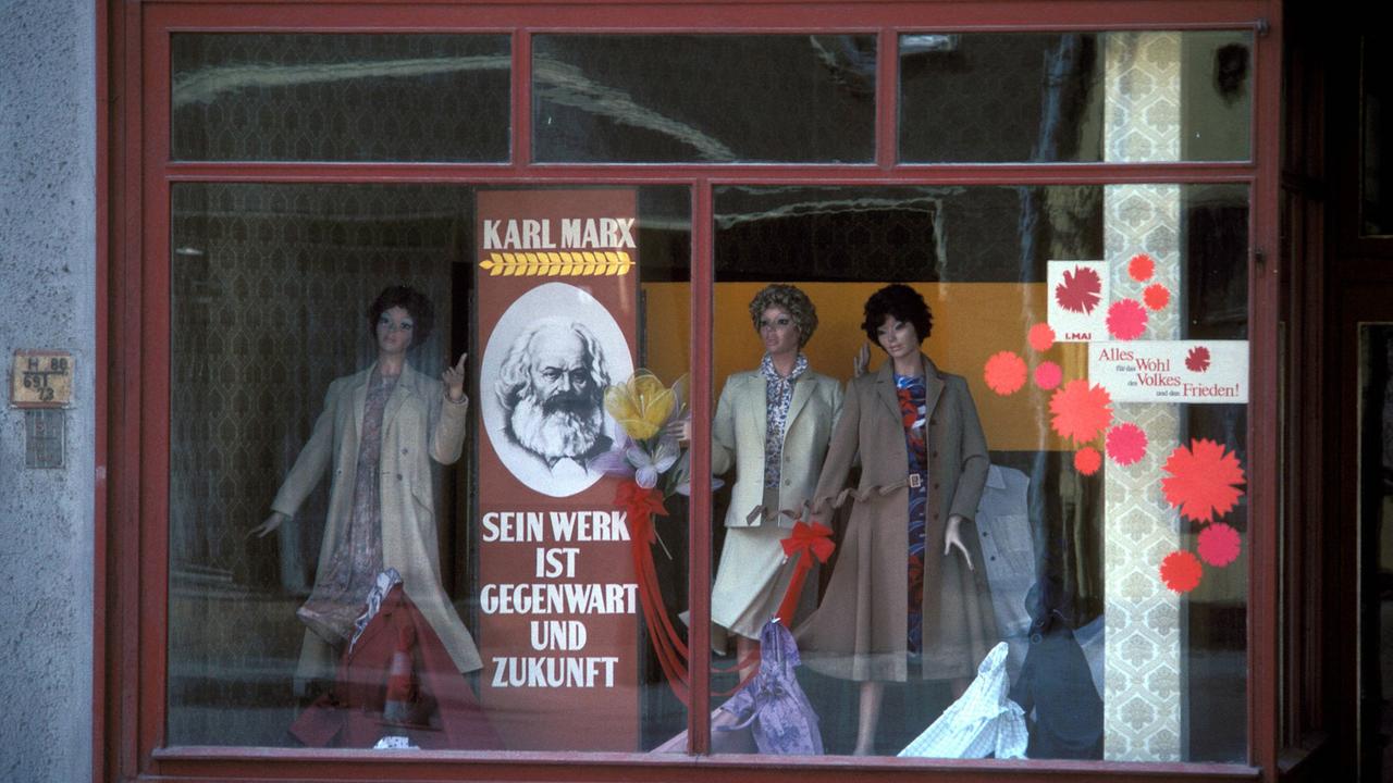 Geschmücktes Schaufenster einer DDR-Modeboutique anlässlich des 1. Mai mit einem Konterfei von Karl Marx im Jahr 1983