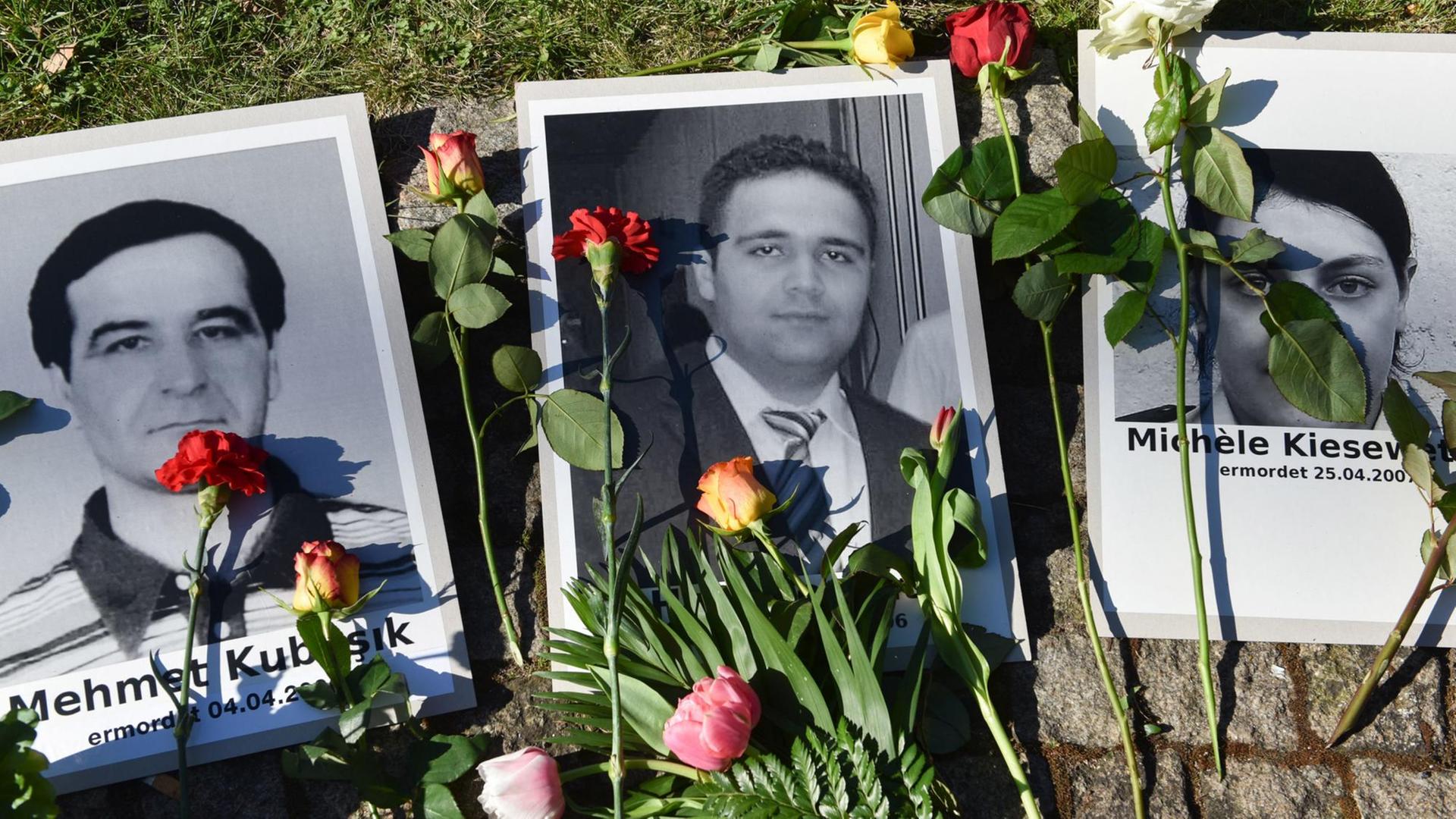 Blumen liegen am Halitplatz neben Porträts des 2006 in Kassel ermordeten Halit Yozgat und anderen Opfern des NSU. Die Stadt Kassel hatte offiziell die Gedenkveranstaltung für Halit Yozgat wegen Sicherheitsbedenken abgesagt. Rund 300 Trauernde versammelten sich am Platz rund um den Gedenkstein.