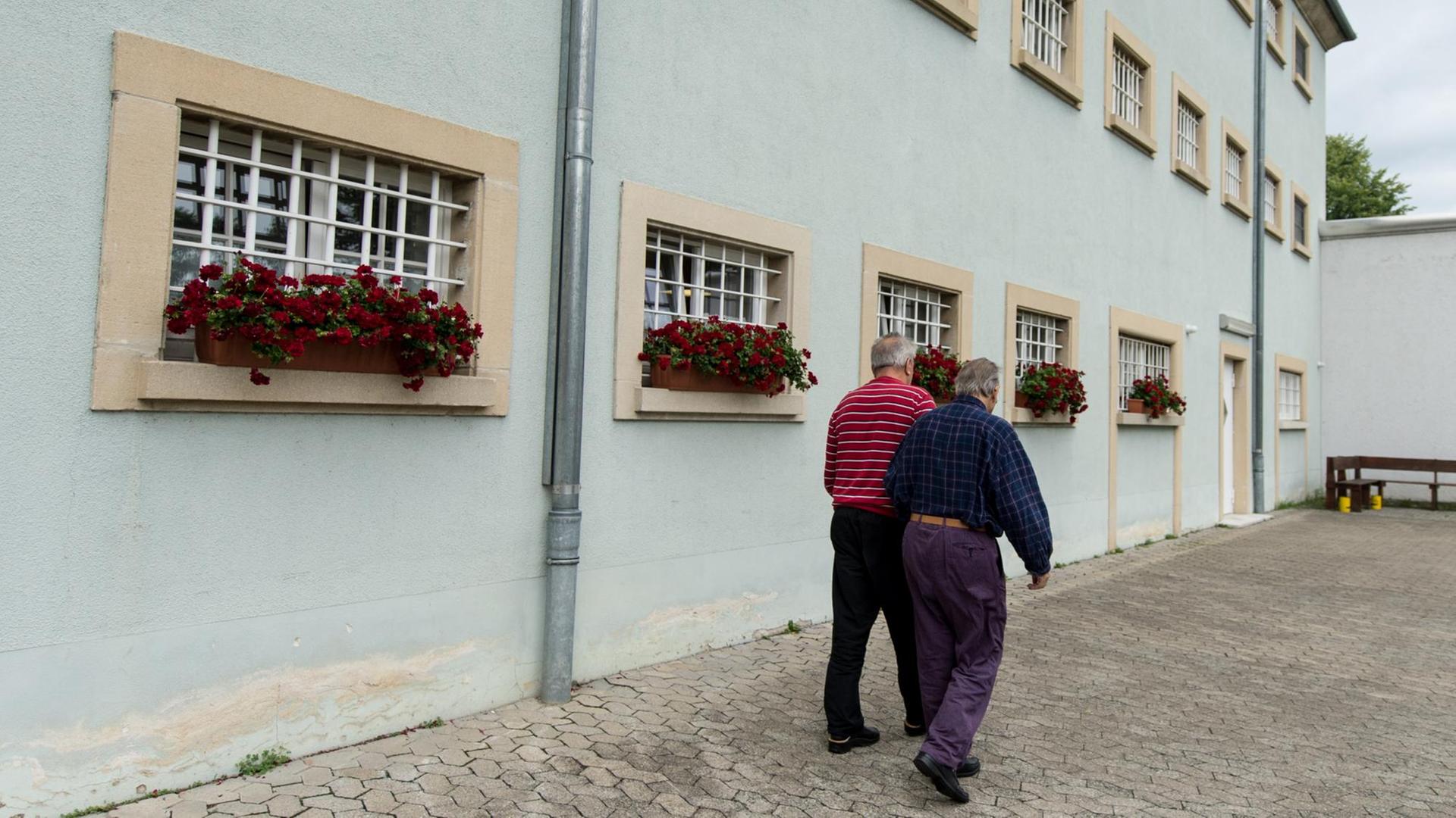 Zwei Insassen der Justizvollzugsanstalt Singen (Baden-Württemberg) laufen am 27.07.2017 im Innenhof des Gefängnisses an vergitterten Fenstern vorbei. Beide sind Senioren. Es ist bundesweit das einzige Gefängnis für Senioren. Zwei Insassen der Justizvollzugsanstalt Singen (Baden-Württemberg) laufen am 27.07.2017 im Innenhof des Gefängnisses an vergitterten Fenstern vorbei. Beide sind Senioren. Es ist bundesweit das einzige Gefängnis für Senioren.