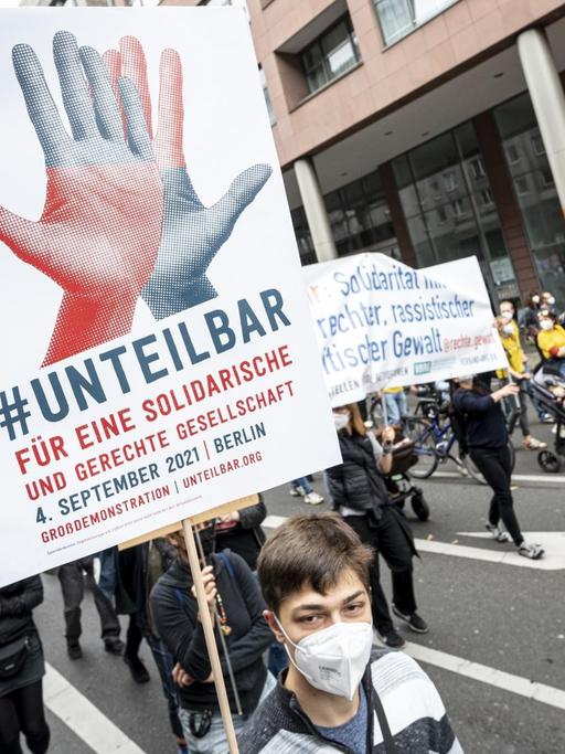 Teilnehmer laufen auf der Demonstration des Bündnisses Unteilbar mit dem Motto «Für eine offene und solidarische Gesellschaft» über die Leipziger Straße in Berlin.