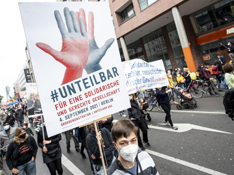Teilnehmer laufen auf der Demonstration des Bündnisses Unteilbar mit dem Motto «Für eine offene und solidarische Gesellschaft» über die Leipziger Straße in Berlin.