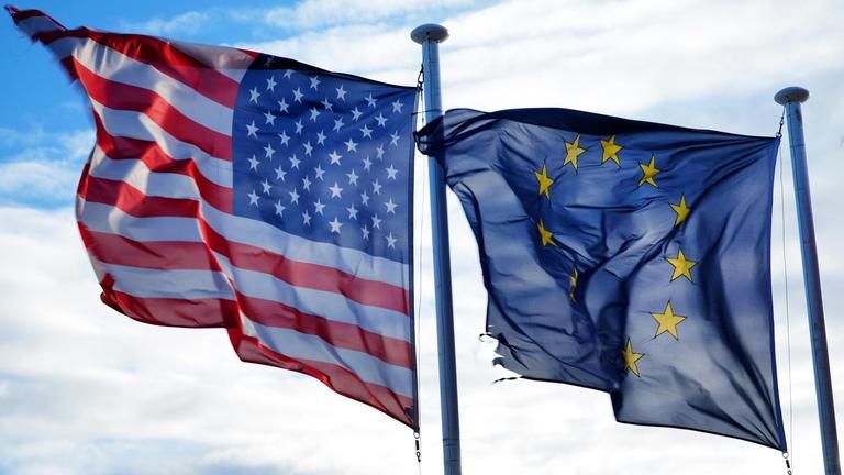 Die Fahnen der Vereinigten Staaten und der Europäischen Union wehen nebeneinander am 04.03.2017 in Nizza (Frankreich) im Wind. Foto: Jens Kalaene/dpa | Verwendung weltweit