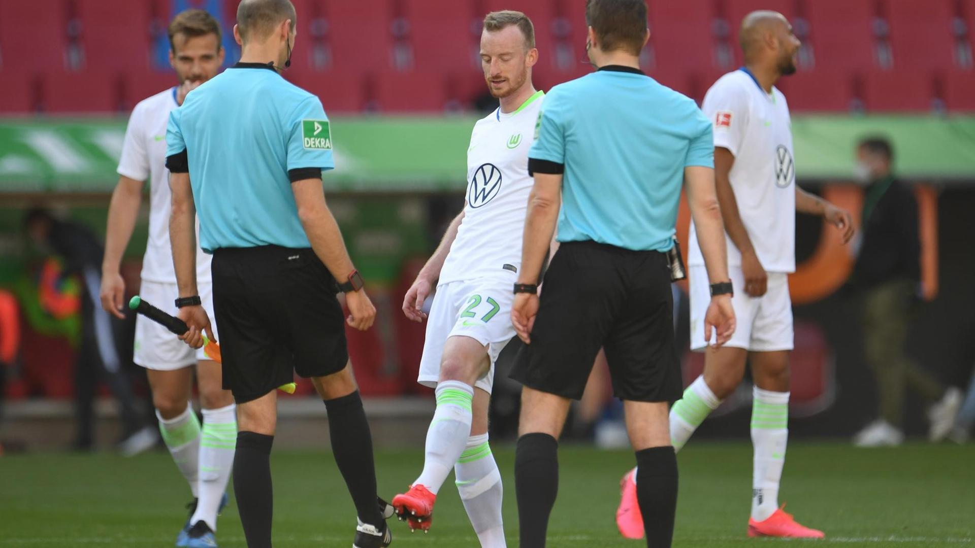 Wolfsburgs Maximilian Arnold verabschiedet sich nach dem Spiel von Assistent Dominik Schaal und Schiedsrichter Felix Brych mit einem Fußabklatschen. Wolfsburgs Maximilian Arnold verabschiedet sich nach dem Spiel von Assistent Dominik Schaal und Schiedsrichter Felix Brych mit einem Fußabklatschen.