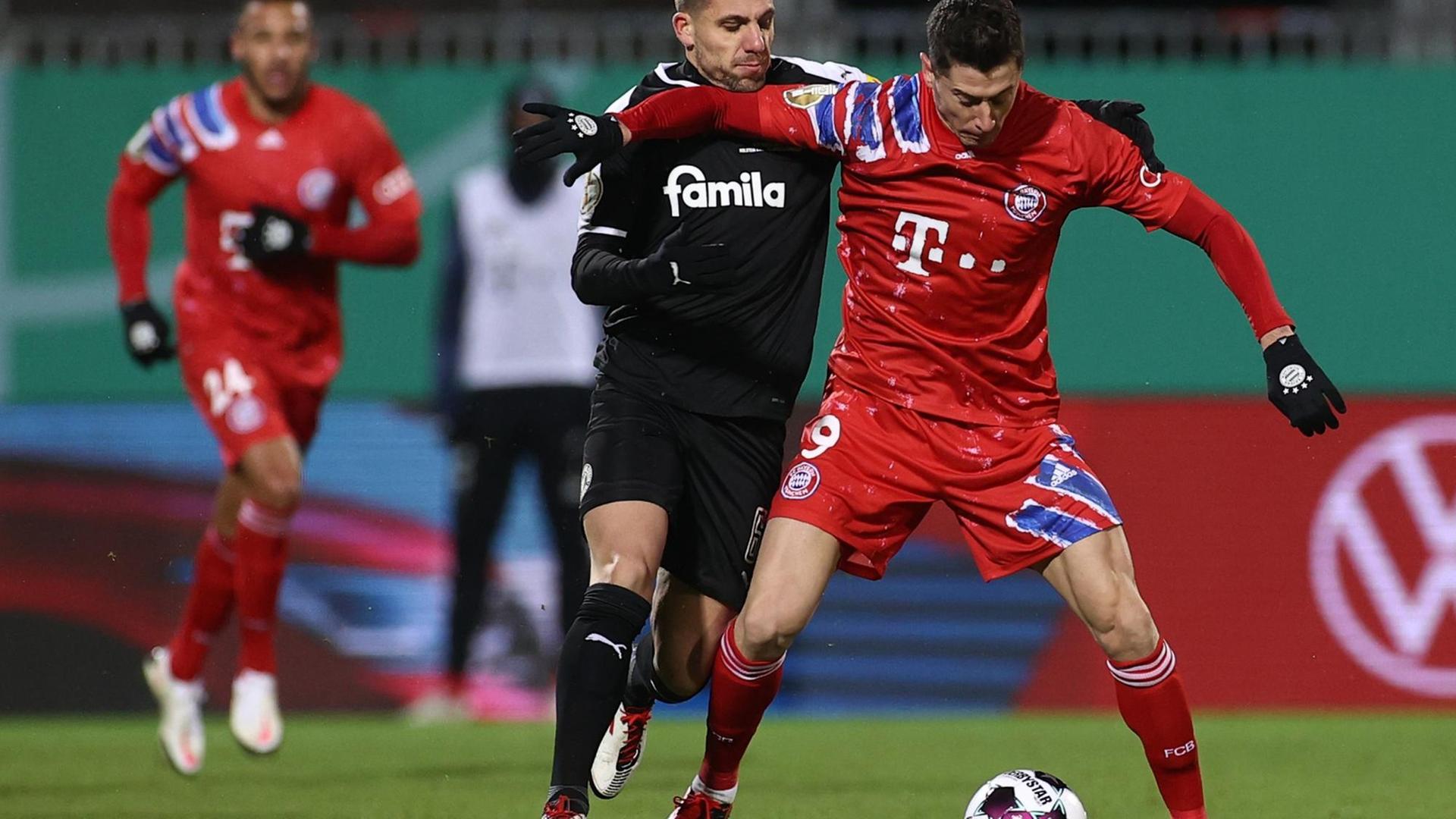 Ahmet Arslan versucht, Robert Lewandowski den Ball abzunehmen