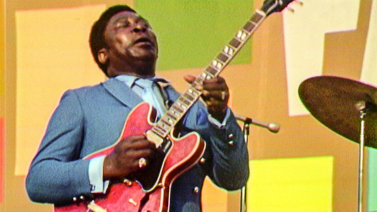 B.B. King spielt Gitarre und singt auf der Bühne. B.B. King spielt Gitarre und singt auf der Bühne.