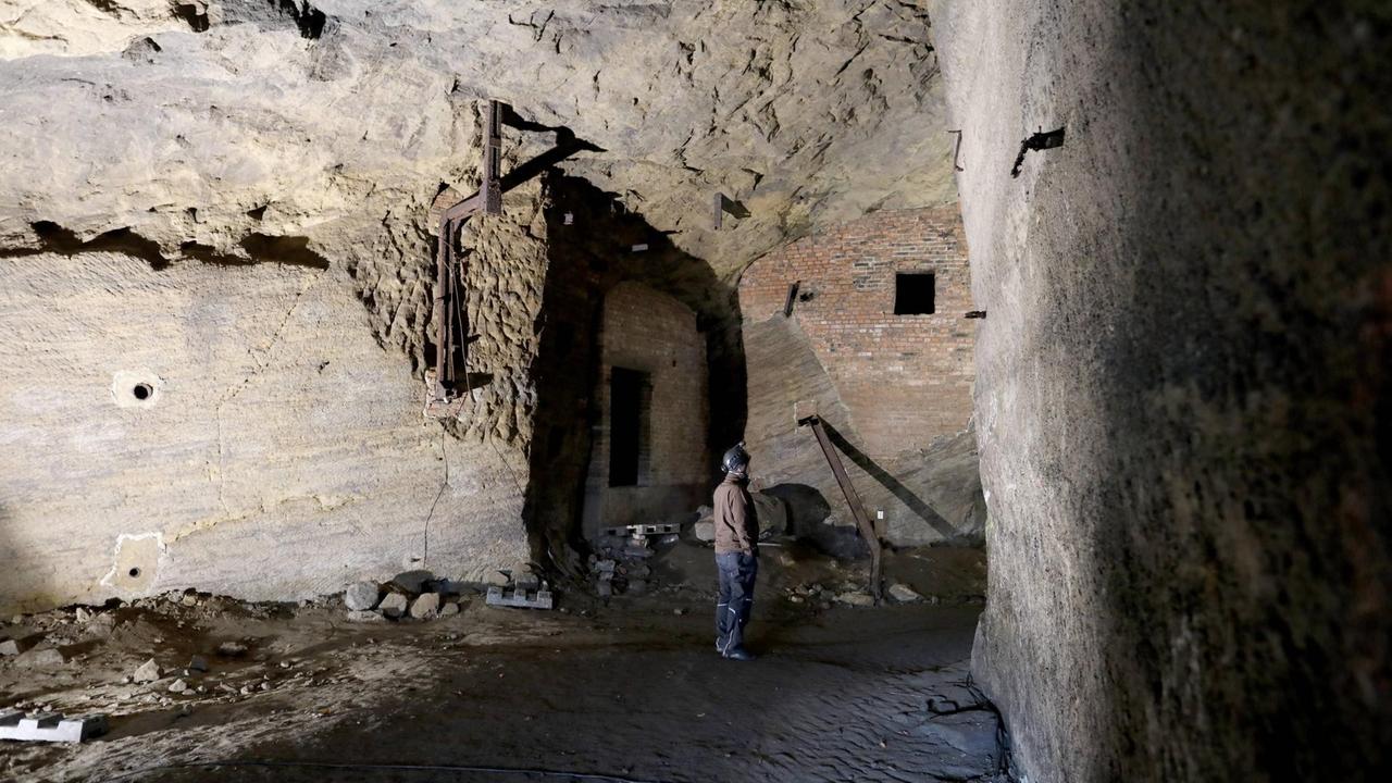 Eine Person steht in einem Raum in der Stollenanlage im Jacobsberg Eine Person steht in einem Raum in der Stollenanlage im Jacobsberg