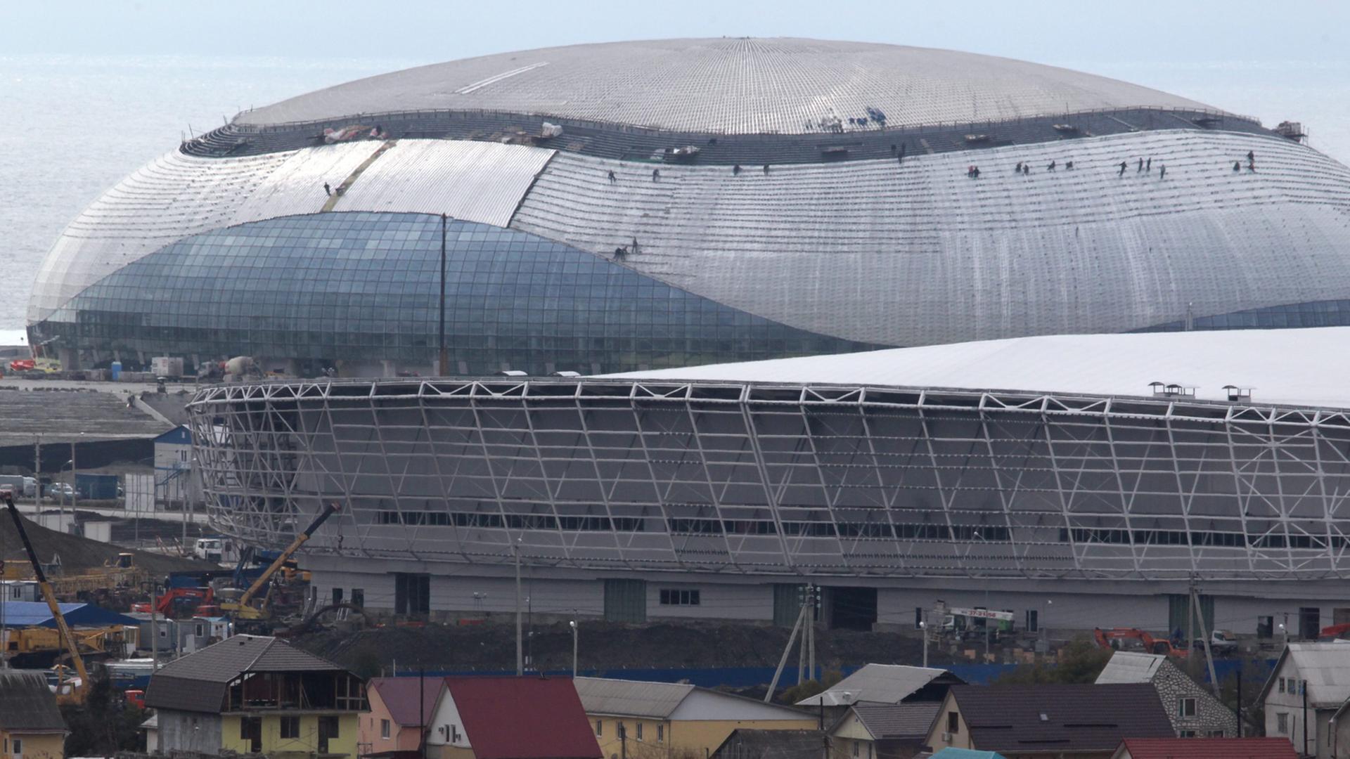 Der Bolschoi-Eispalast im Olympiapark ragt über die Häuser am Stadtrand von Sotschi. Der Bolschoi-Eispalast im Olympiapark ragt über die Häuser am Stadtrand von Sotschi.