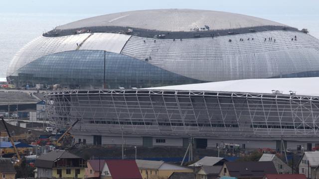 Der Bolschoi-Eispalast im Olympiapark ragt über die Häuser am Stadtrand von Sotschi.
