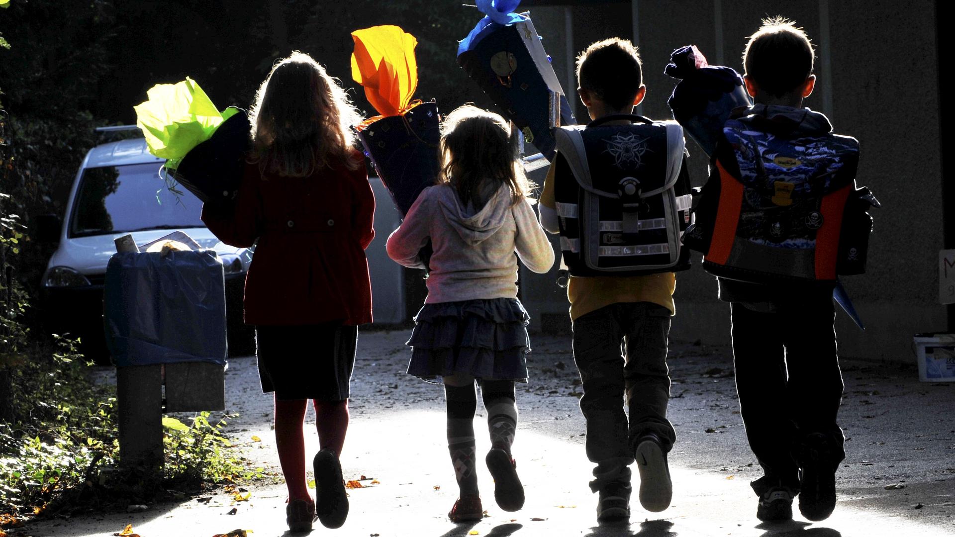 Vier Kinder mit Schultüten auf dem Weg zur Einschulung Vier Kinder mit Schultüten auf dem Weg zur Einschulung