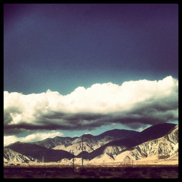 In einer Instagram-Polaroid Ästhetik sehen wir ein Gebirge in Nevada, über welches eine Wolke hinweg zieht.
