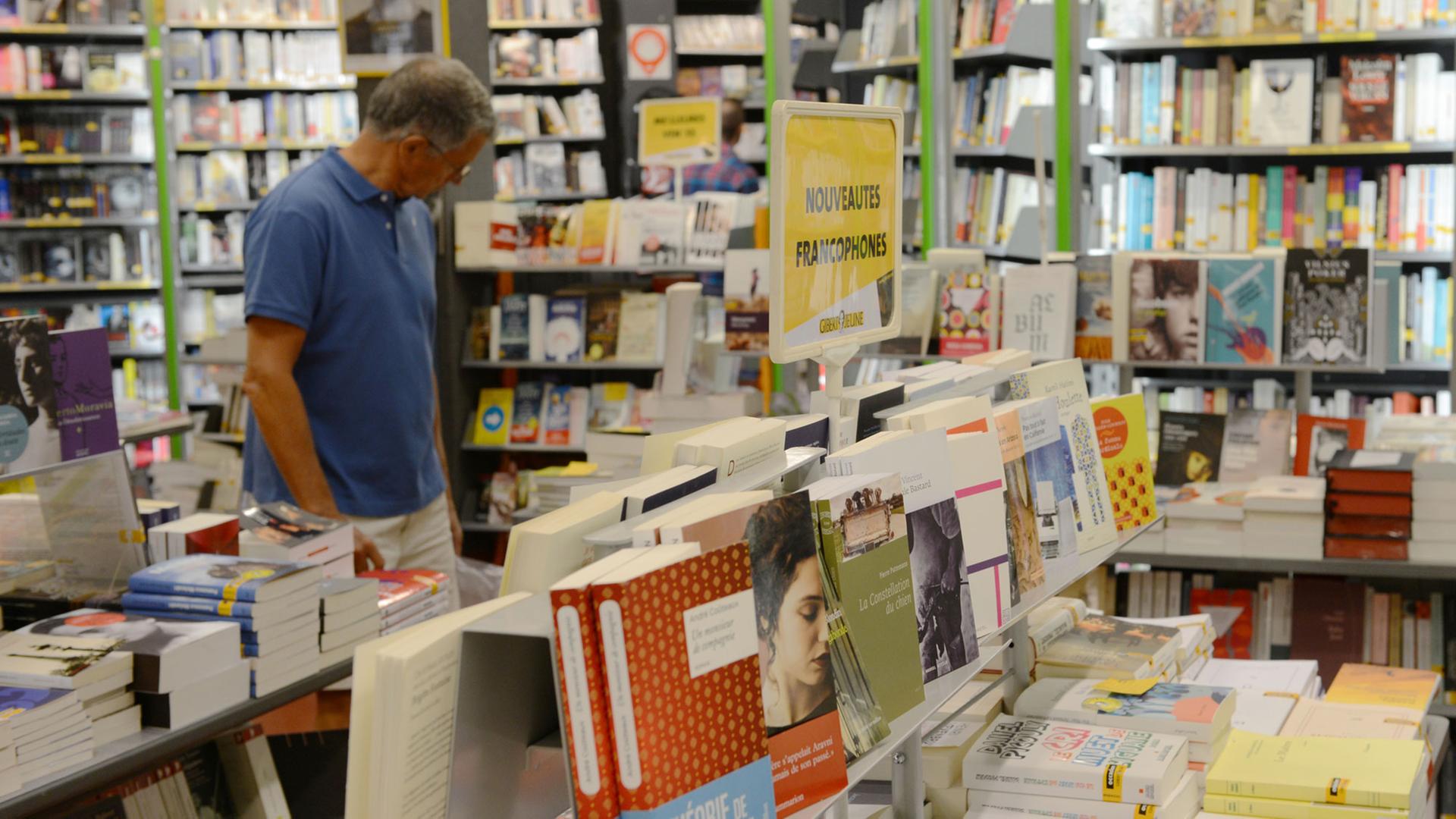 Ein Kunde im Buchladen Gibert Jeune im Viertel Saint-Michel in Paris betrachtet die Bücher.