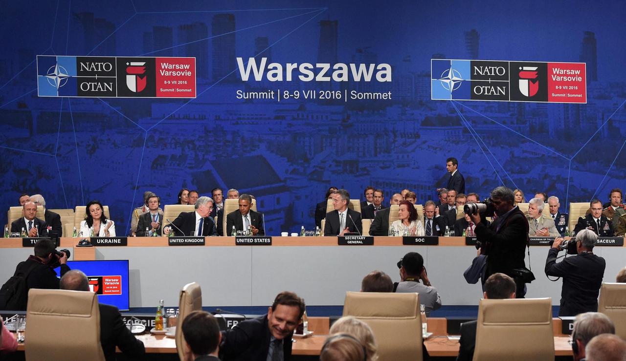 Die Teilnehmer des Nato-Gipfels in Warschau sitzen um einen Konferenztisch. In der Mitte US-Präsident Obama und Nato-Generalsekretär Stoltenberg Die Teilnehmer des Nato-Gipfels in Warschau sitzen um einen Konferenztisch. In der Mitte US-Präsident Obama und Nato-Generalsekretär Stoltenberg