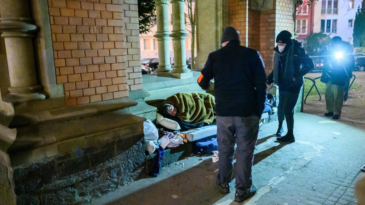 Zwei Sozialarbeiter vom Frankfurter Kältebus sehen nach einem Obdachlosen, der im Durchgang einer Kirche schläft. Zwei Sozialarbeiter vom Frankfurter Kältebus sehen nach einem Obdachlosen, der im Durchgang einer Kirche schläft.