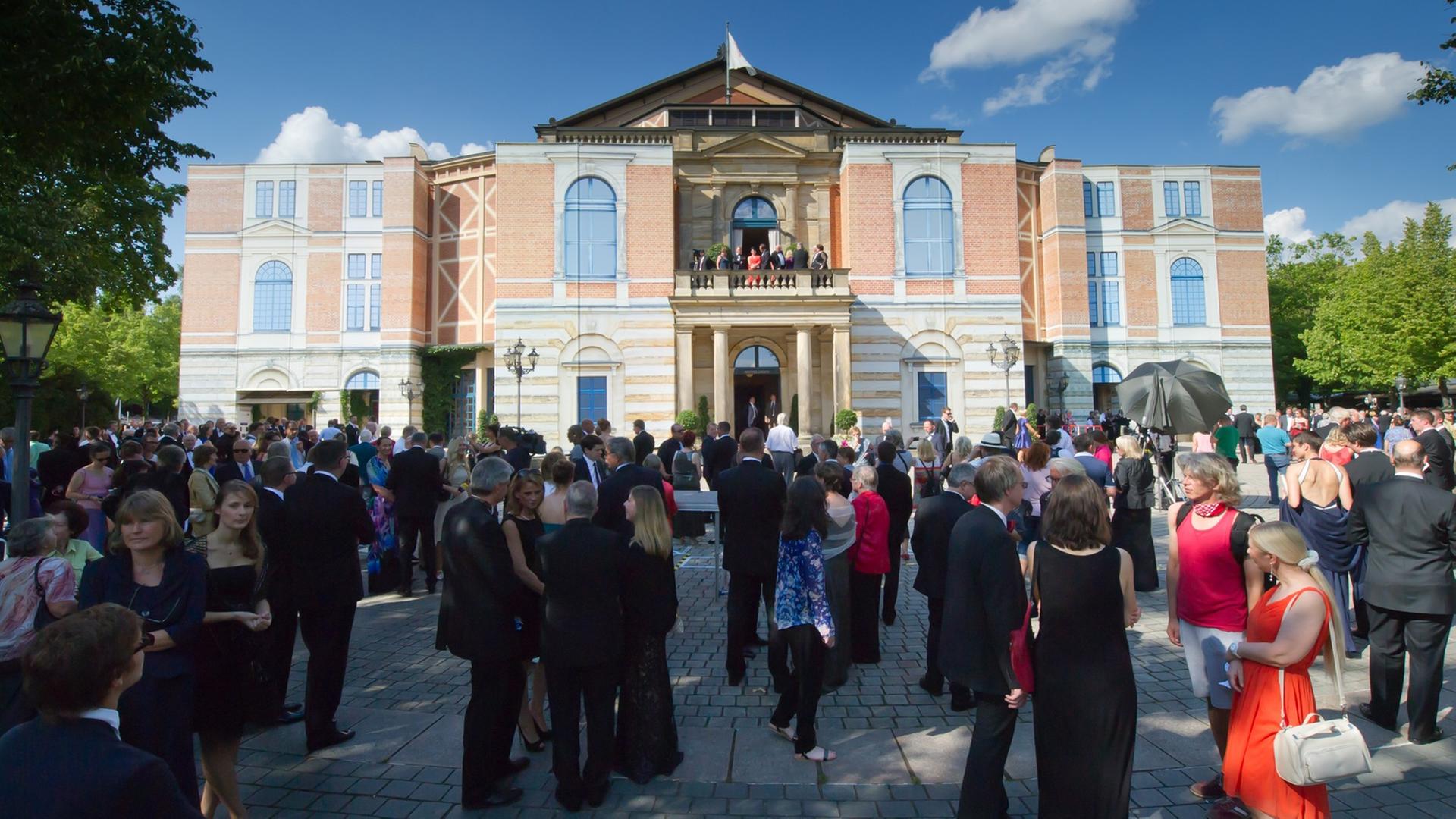Besucher warten am 25.07.2014 bei der Eröffnung der Bayreuther Festspiele auf dem Grünen Hügel in Bayreuth (Bayern) bei einer unplanmäßigen Unterbrechung wegen eines technischen Defekts vor dem Festspielhaus. Besucher warten am 25.07.2014 bei der Eröffnung der Bayreuther Festspiele auf dem Grünen Hügel in Bayreuth (Bayern) bei einer unplanmäßigen Unterbrechung wegen eines technischen Defekts vor dem Festspielhaus.