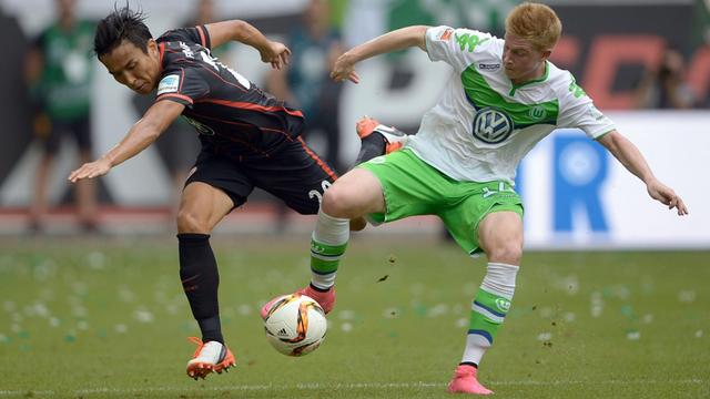 Der Wolfsburger Kevin de Bruyne und der Frankfurter Makoto Hasebe kämpfen um den Ball.