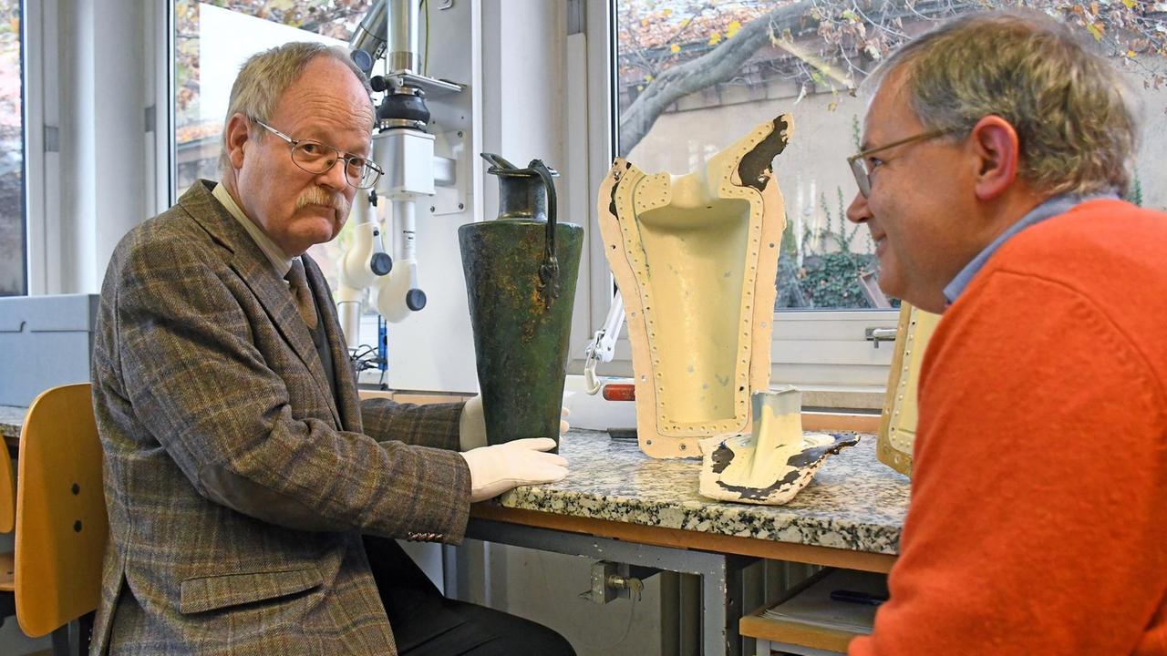 Kriminalarchäologe Michael Müller-Karpe (links) und der Keltenexperte Martin Schönfelder sitzen vor der Kopie einer keltischen Schnabelkanne aus dem 4. Jahrhundert v. Chr. Kriminalarchäologe Michael Müller-Karpe (links) und der Keltenexperte Martin Schönfelder sitzen vor der Kopie einer keltischen Schnabelkanne aus dem 4. Jahrhundert v. Chr.