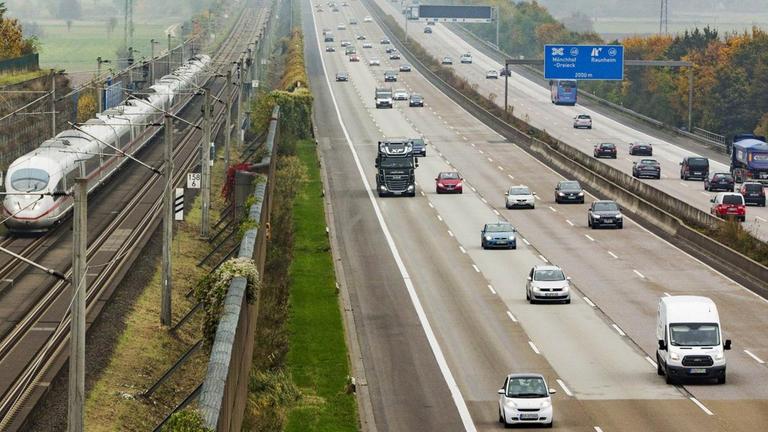 Autos fahren auf der Autobahn A3 neben der Hochgeschwindigkeitstrasse der Bahn, auf der ein ICE fährt Autos fahren auf der Autobahn A3 neben der Hochgeschwindigkeitstrasse der Bahn, auf der ein ICE fährt