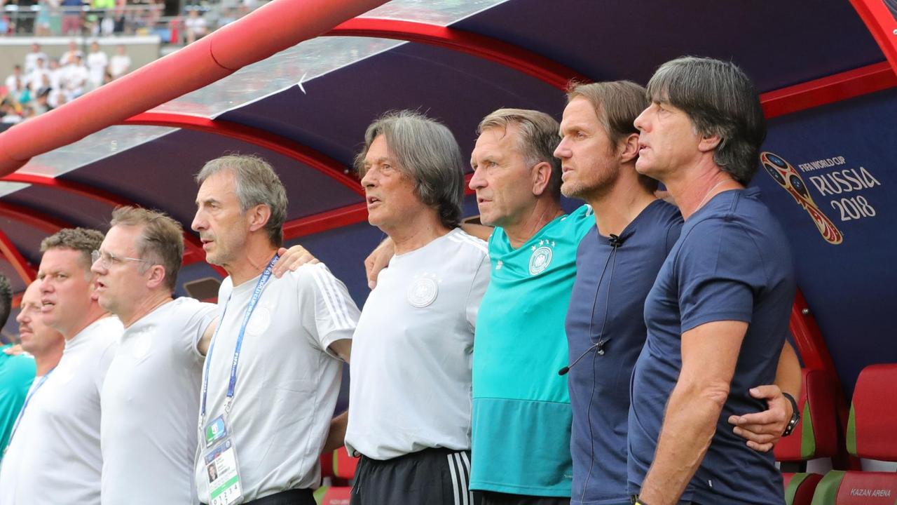DFB-Bundestrainer Joachim Löw (r.) und Mannschaftsarzt Tim Meyer (2.v.l.) stehen bei der Nationalhymne zusammen vor der Bank. DFB-Bundestrainer Joachim Löw (r.) und Mannschaftsarzt Tim Meyer (2.v.l.) stehen bei der Nationalhymne zusammen vor der Bank.