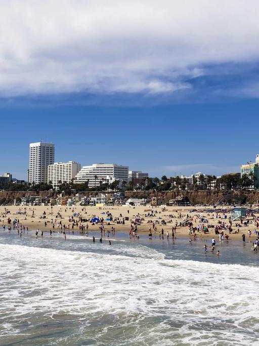 Blick auf den Santa Monica State Beach im kalifornischen Los Angeles, im Hintergrund sind Hochhäuser zu sehen