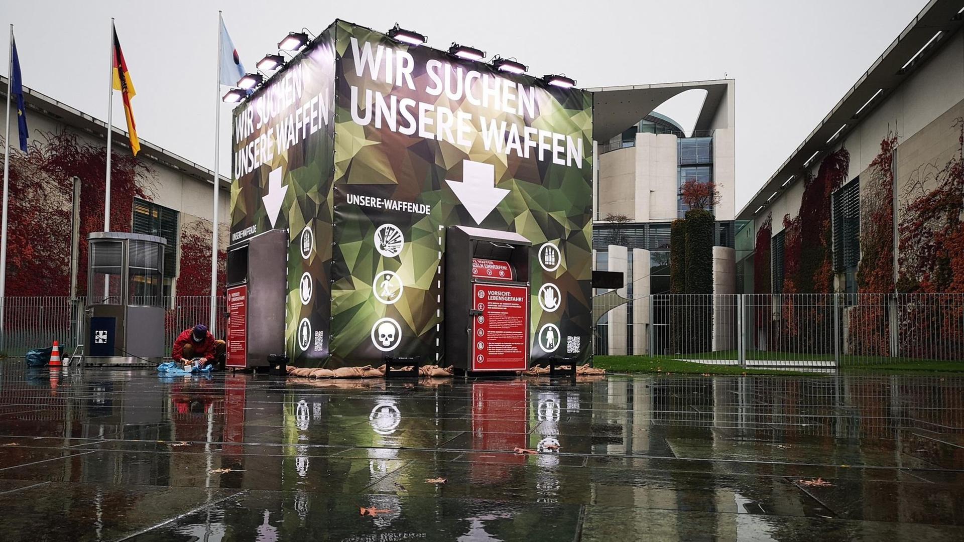 Container in Tarnfarben mit der Aufschrift "Wir suchen unsere Waffen" vor dem Berliner Kanzleramt. Container in Tarnfarben mit der Aufschrift "Wir suchen unsere Waffen" vor dem Berliner Kanzleramt.