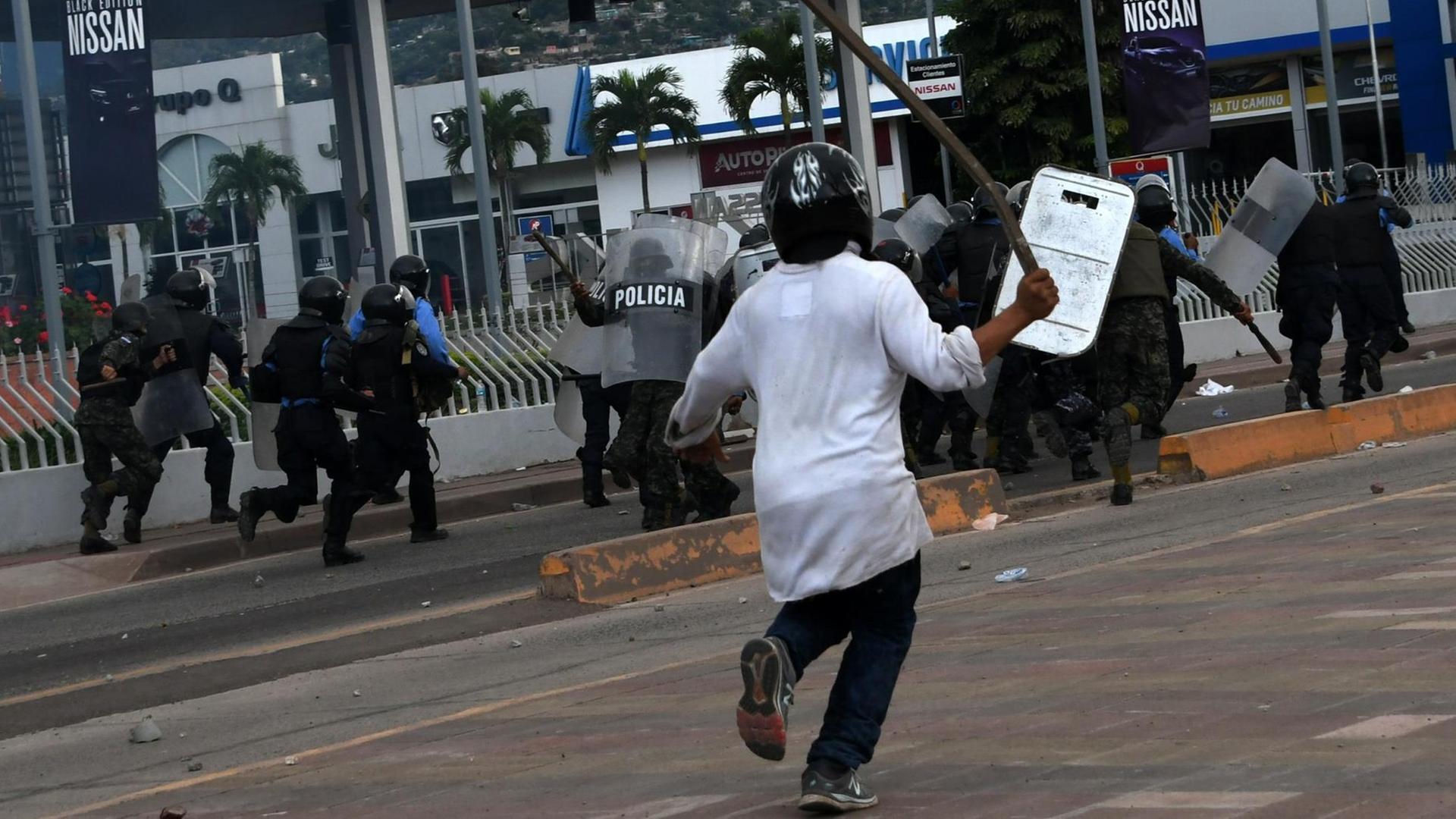 Soldaten und Polizeikräfte in Schutzkleidung flüchten vor den wütenden Anhängern des Oppositionsführers von Honduras, Salvador Nasralla. Die Demonstranten befinden sich in der Nähe des Wahlamtes von Tegucigalpa. Nasralla hatte seine Anhänger aufgefordert, auf die Straße zu gehen und seinen Sieg zu verteidigen. Soldaten und Polizeikräfte in Schutzkleidung flüchten vor den wütenden Anhängern des Oppositionsführers von Honduras, Salvador Nasralla. Die Demonstranten befinden sich in der Nähe des Wahlamtes von Tegucigalpa. Nasralla hatte seine Anhänger aufgefordert, auf die Straße zu gehen und seinen Sieg zu verteidigen.