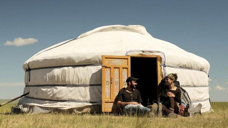 Patrick Allgaier und Gwendolin Weisser sitzen in der Mongolei vor einer Jurte für Gäste.