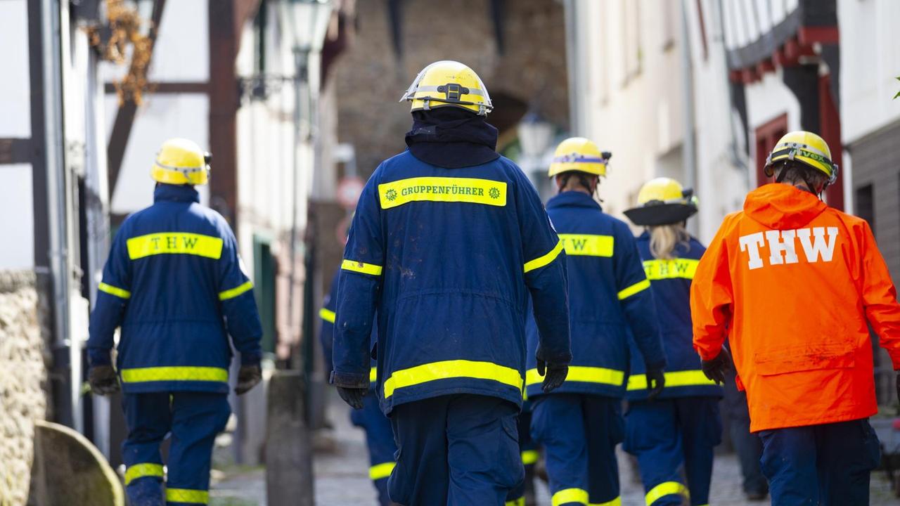 Einsatzkräfte des Technischen Hilfswerks gehen bei Räumarbeiten nach der Unwetter-Katastrophe in Nordrhein-Westfalen durch den zerstörten Ort Bad Münstereifel.